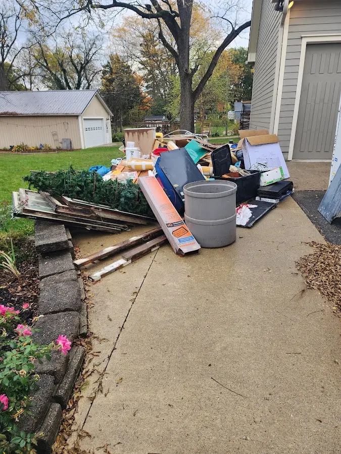 Dumpster being loaded with debris for Estate Cleanout Dumpster Rental in Blissfield